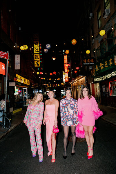 four woman stand in street