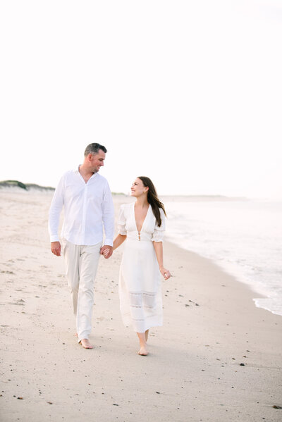 couple walking the beach during their nauset beach sunset engagement session