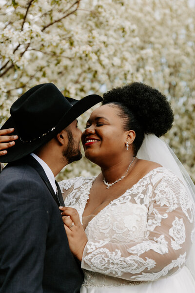 Newlyweds smiling as they are about to kiss