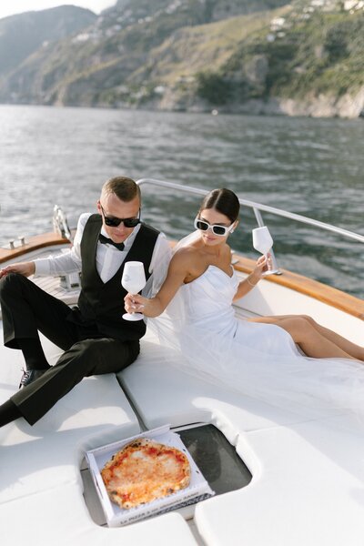 Wedding couple eating pizza on a boat in Lake Como