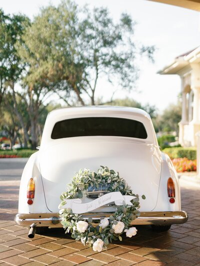 White vintage car with "just married" wreath