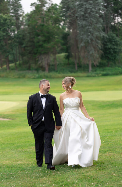 bride and groom embrace in front of the entrance of Meadow Brook Hall in Rochester Hills, MI