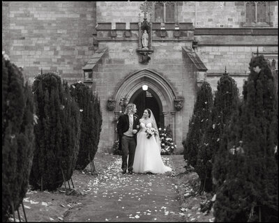 black and white nostalgic photograph of bride and groom with confetti at their wedding venue in York, UK