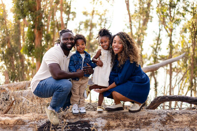 Bay Area Family Photographer Smiling family portrait with kids on a log at Coyote Point San Mateo