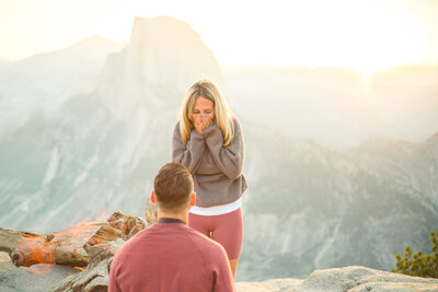 A wedding proposal between two hikers at sunrise in front of Half Dome in Yosemite National Park.