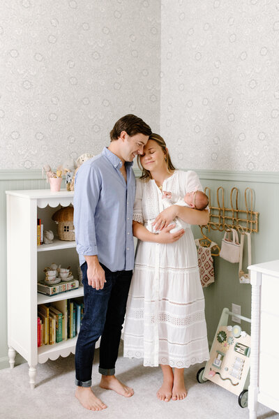 Parents holding baby and standing in nursery during in-home newborn photos with  Indianapolis Newborn Photographer, Capturing Simplicity Photography