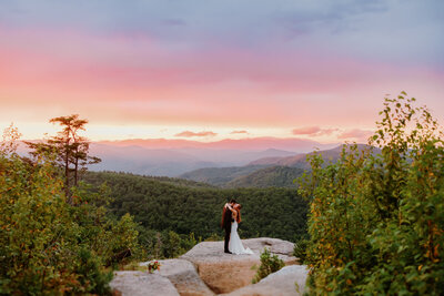 elopement on a mountaintop at sunset bride and groom hug