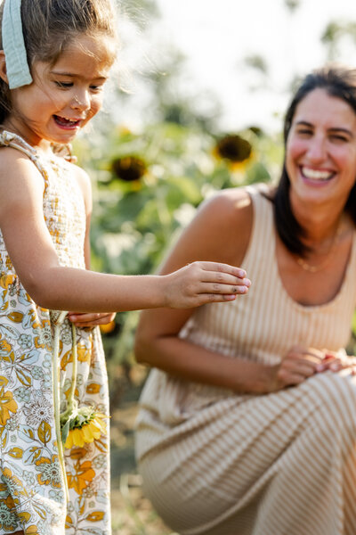 Authentic mother-daughter moment photographed in Indiana sunflower field by family photographer