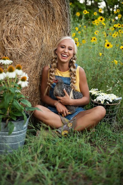 high school senior pictures farm themed shoot girls dreessed in ovralls posing with red tractor