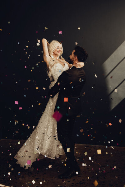 bride and groom hugging with confetti around them