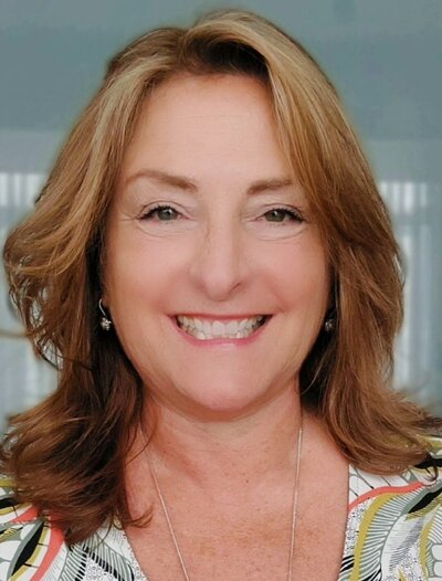 Woman portrait with shoulder length auburn hair and pattern shirt