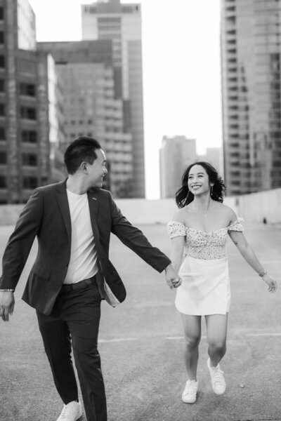 black and white image of a couple running at Downtown Austin Rooftop