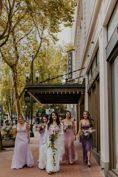 bridesmaids in purple dresses walking in downtown