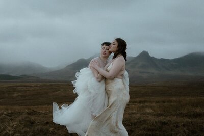 Two brides brace the strong winds and cold temperatures prior to marrying on the Isle of Skye's Quairaing, Scotland