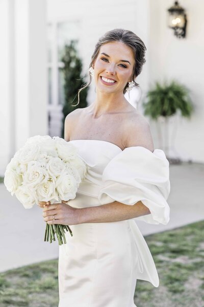 Bridal makeup with bold earrings and white bouquet