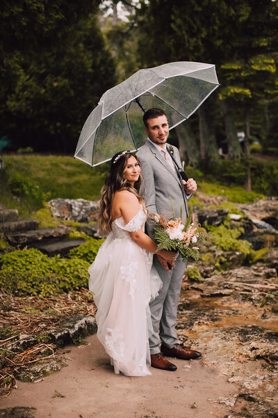 Bride and groom  hold an umbrella at Gordon Lodge Wedding