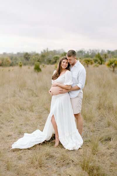 Maternity photography couples photo pregnant woman with husband in field In Tampa Bay, Florida Nadine B Photography