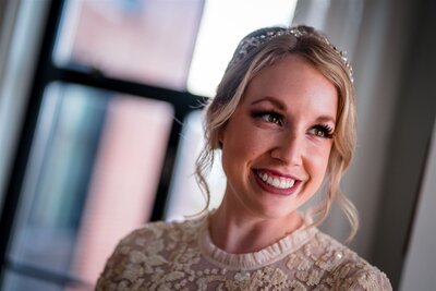 A bride smiles while wearing a sparkly lace dress and matching headband at the line hotel in washington dc