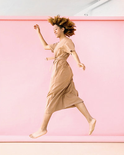Canva - Woman Wearing Brown Dress Jump Near Pink Wall