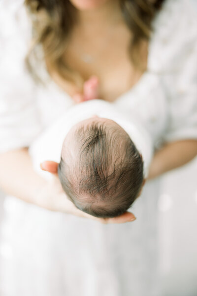Baby in neutral pink wrap lying in a moses basket for a Tampa portrait photographer