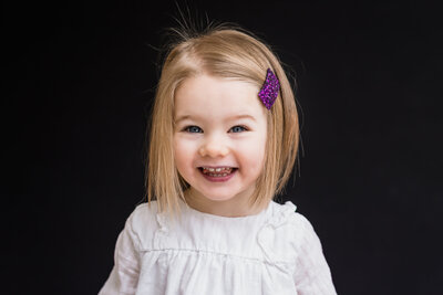 Blonde toddler with sparkly purple hair clip | Meg Sivakumar Boutique School Portraits in Woodinville, WA