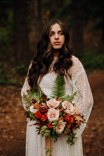 woman holding bouquet in forest