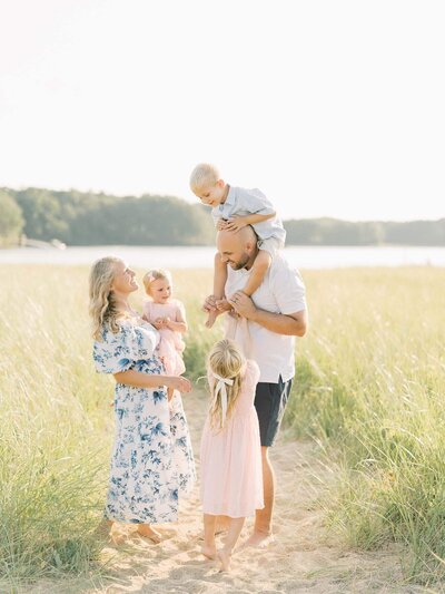 family of five play on the beach By Carrie Pellerin