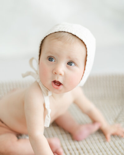 Baby sits and looks surprised