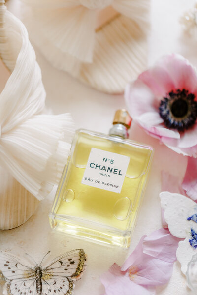 Chanel Perfume next to shoes and flowers