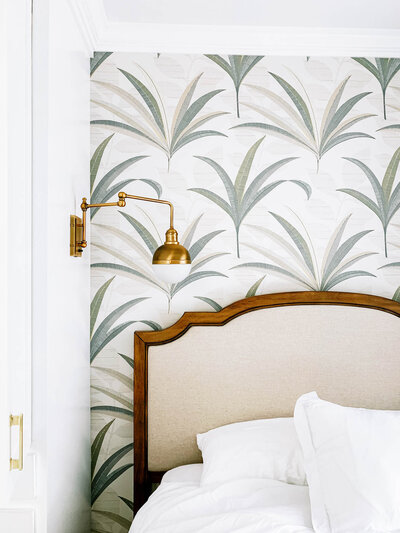 upholstered bed and palm tree wallpaper