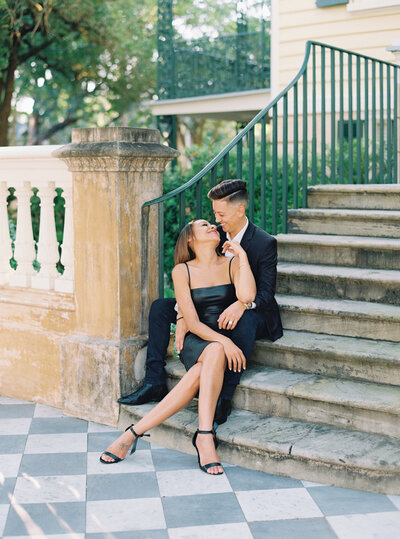 Couple on steps in downtown Charleston with checkerboard floor.