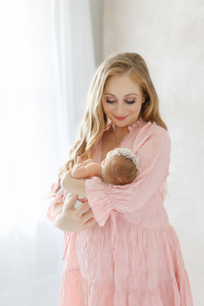Newborn baby girl peacefully posed in neutral-toned wrap during high-end Tampa studio session