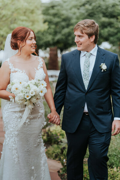 bride and groom walking while holding bridal bouquet