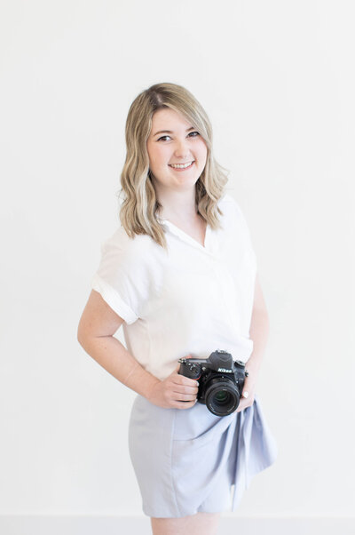 photographer holding camera at her waist