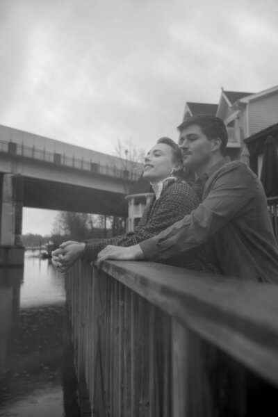 Gracie and Dean embrace and look over the river together during their engagement session.