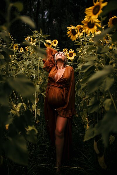Pregnant woman posing in sunflower field