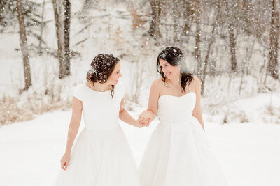two brides walking in snow