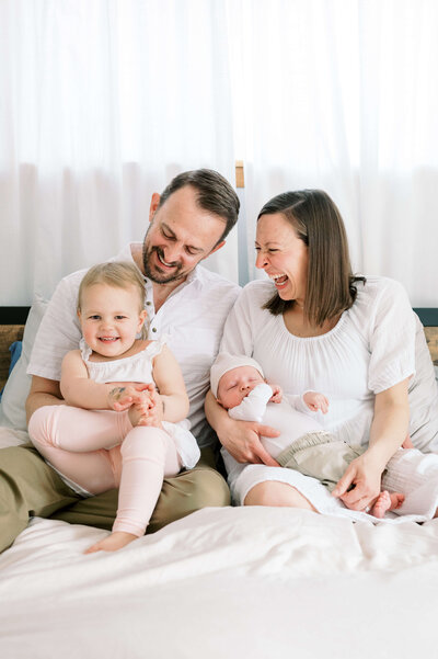 A sweet family smile and laugh with their toddler during their northern virginia family photo session