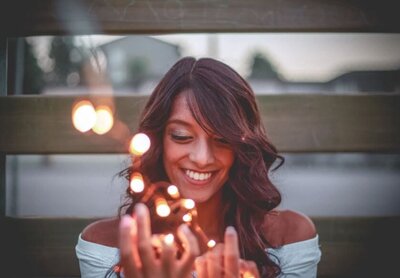 woman smiling while holding lights