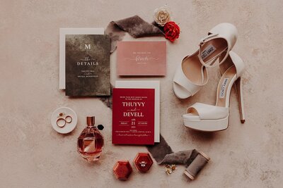 Wedding detail photo of bride's shoes and perfume and invitation suite