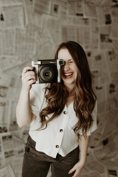 woman holding camera and smiling