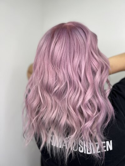 Image of client with hair that has been dyed completely light pink.