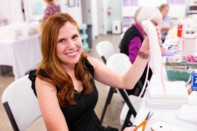 Volunteer threads ribbon on cradle for stillborn baby girl