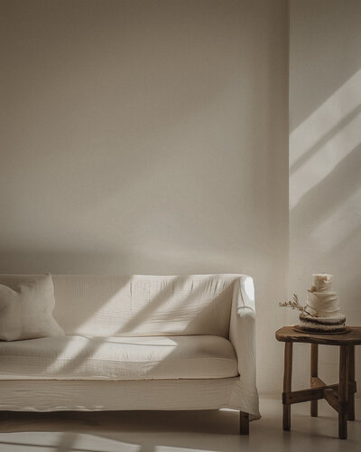 Sunlit neutral-toned therapy space with a cozy couch and candle, symbolizing safety, calm, and nervous system regulation in trauma therapy with Jessie Withers, Los Angeles, CA