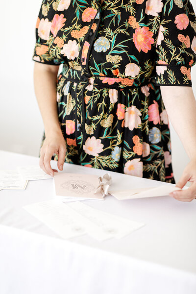 a woman in a floral dress handling a  custom wedding program
