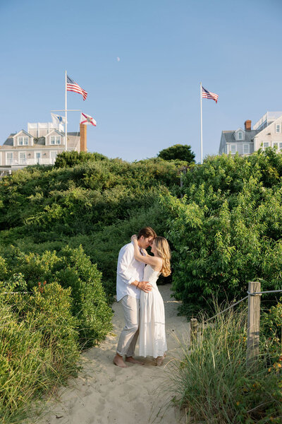 A couple facing each other and foreheads touching on Steps Beach Nantucket