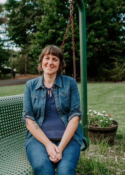 Erin, Therapist at First Star Psychotherapy, smiling in front of lake and trees