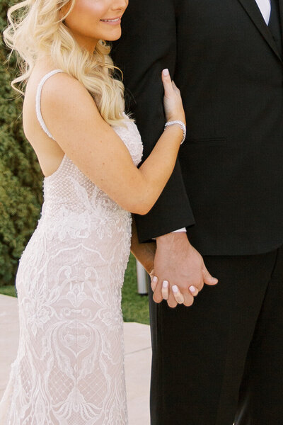 Close up photo of couple holding hands and walking taken by Orange county wedding photographer
