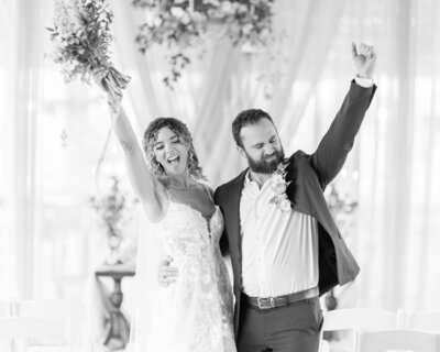 Bride and groom celebrating with hands in the air