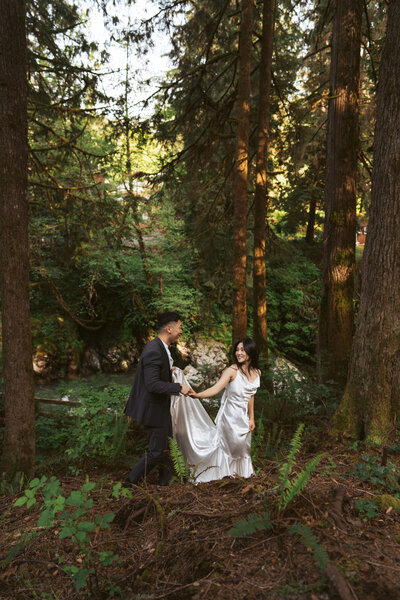elopement couple walks through the forested property of the Airbnb where they had their remote, destination elopement
